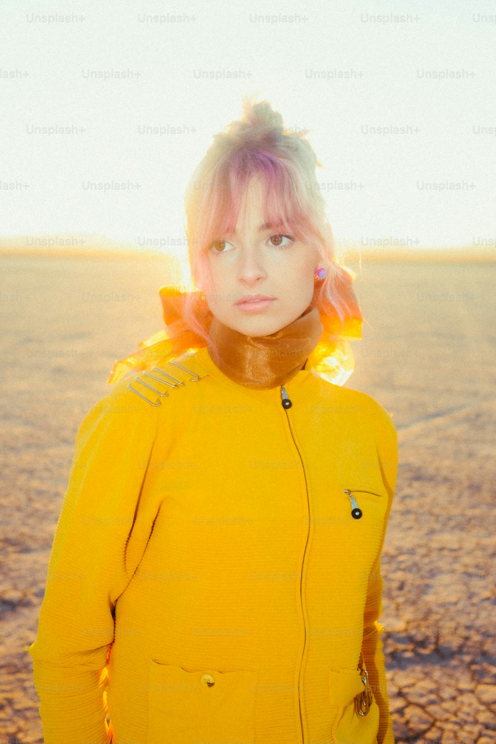 a woman in a yellow jacket standing in the desert