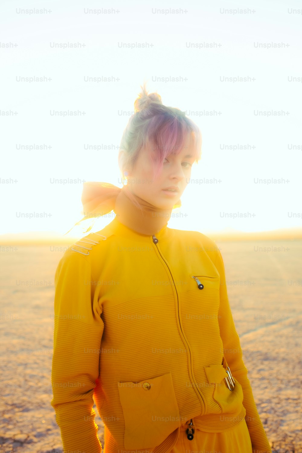 Una mujer con un traje amarillo parada en el desierto