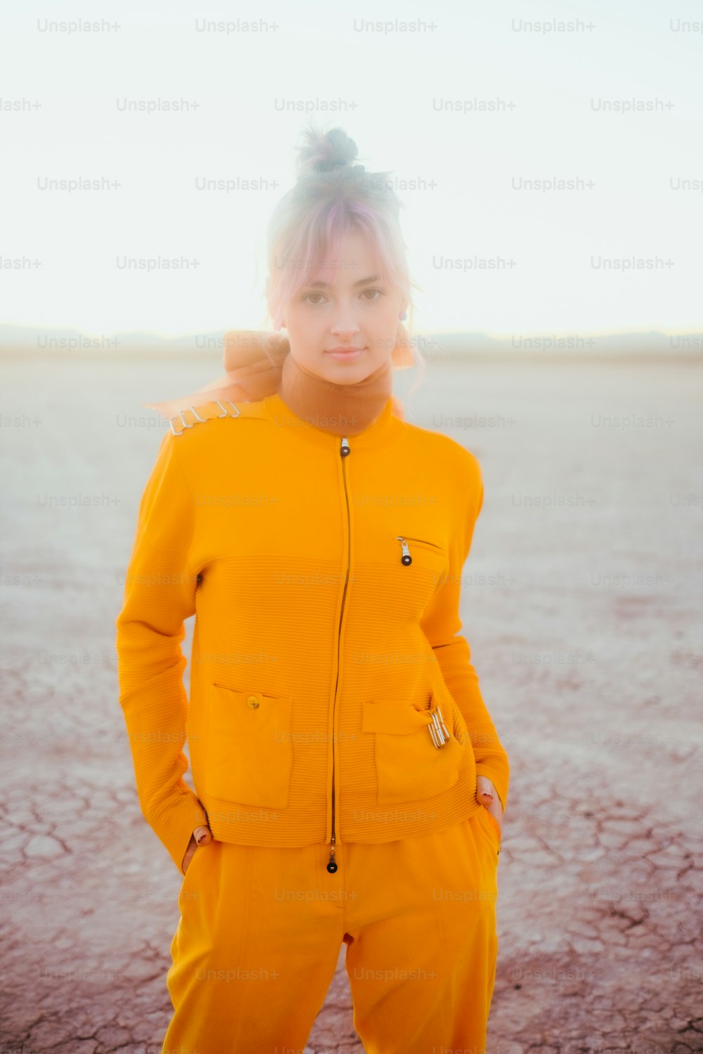 砂漠に立つ黄色いスーツを着た女性
