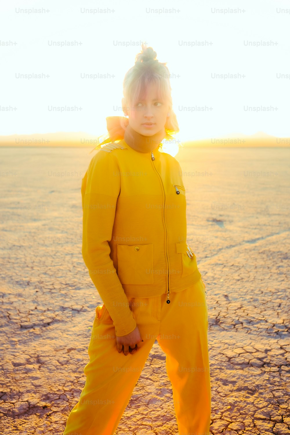 砂漠に立っている黄色いスーツを着た人