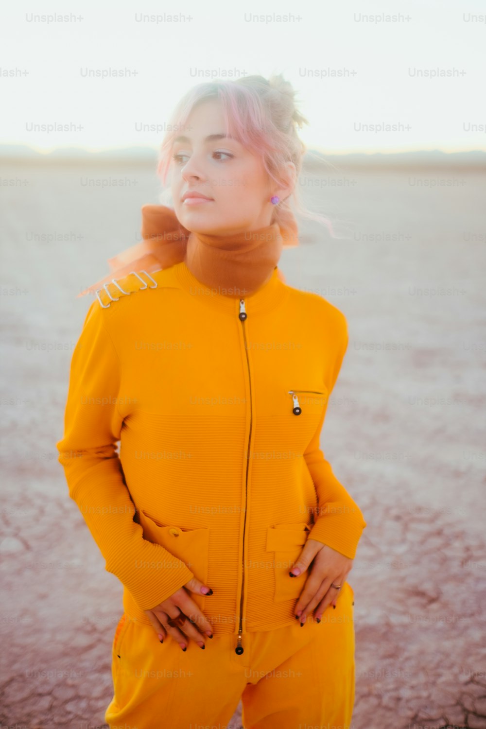 a woman in a yellow suit standing in the desert