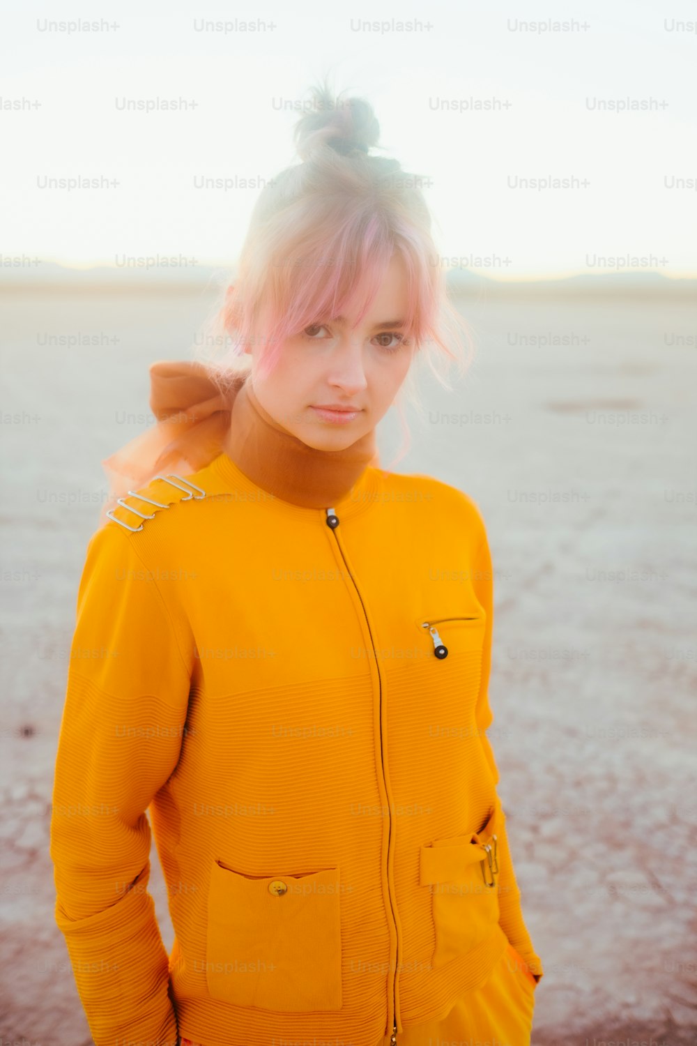 Una mujer con cabello rosa con una chaqueta amarilla