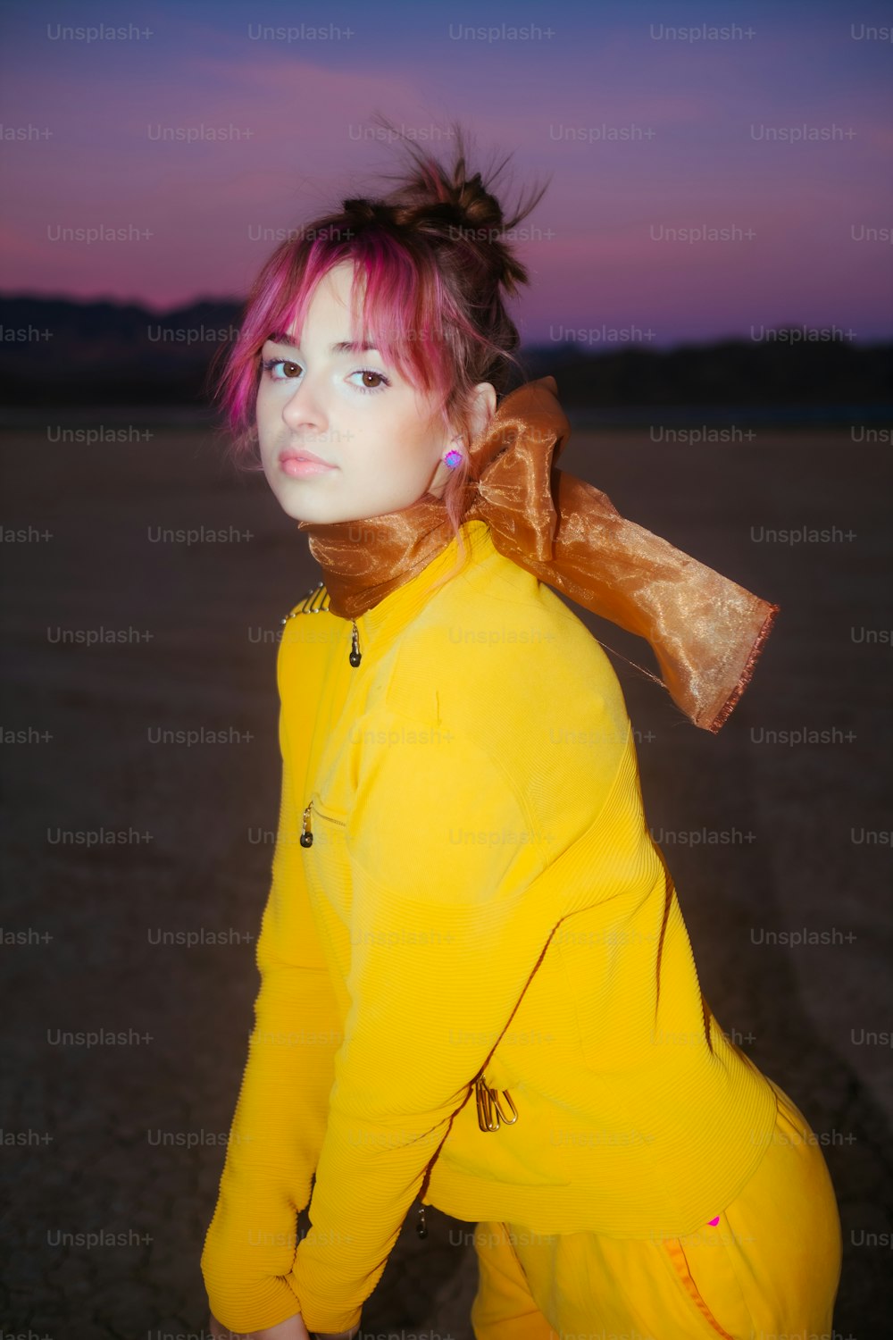 a woman with pink hair wearing a yellow outfit