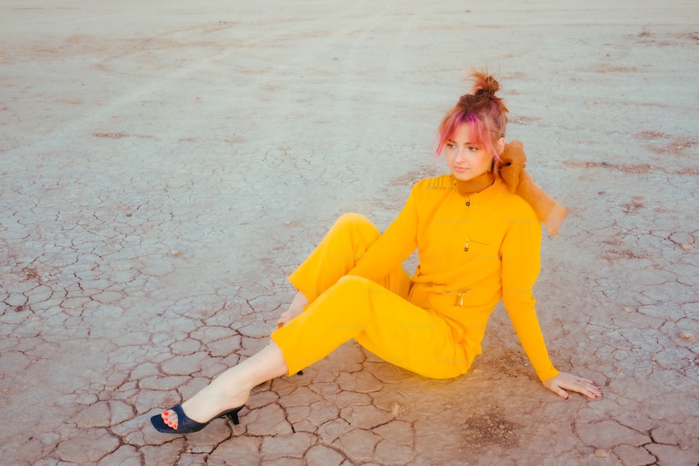 Una mujer con un traje amarillo sentada en el suelo
