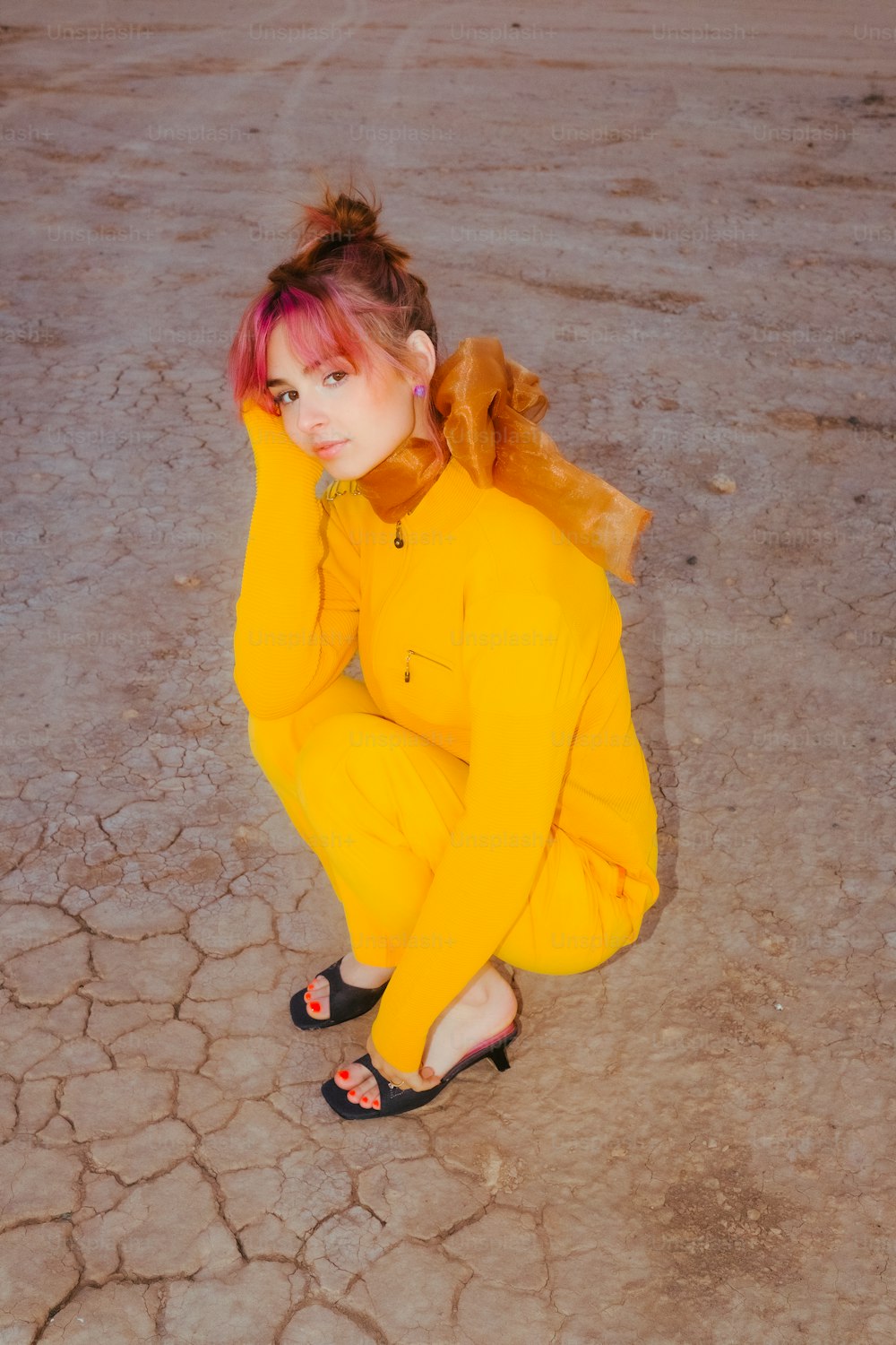 a woman with pink hair sitting on the ground