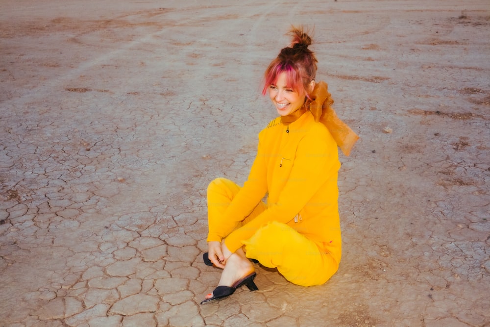 a woman in a yellow outfit sitting on the ground
