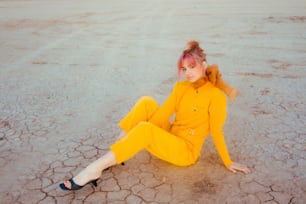 a woman with pink hair sitting on the ground