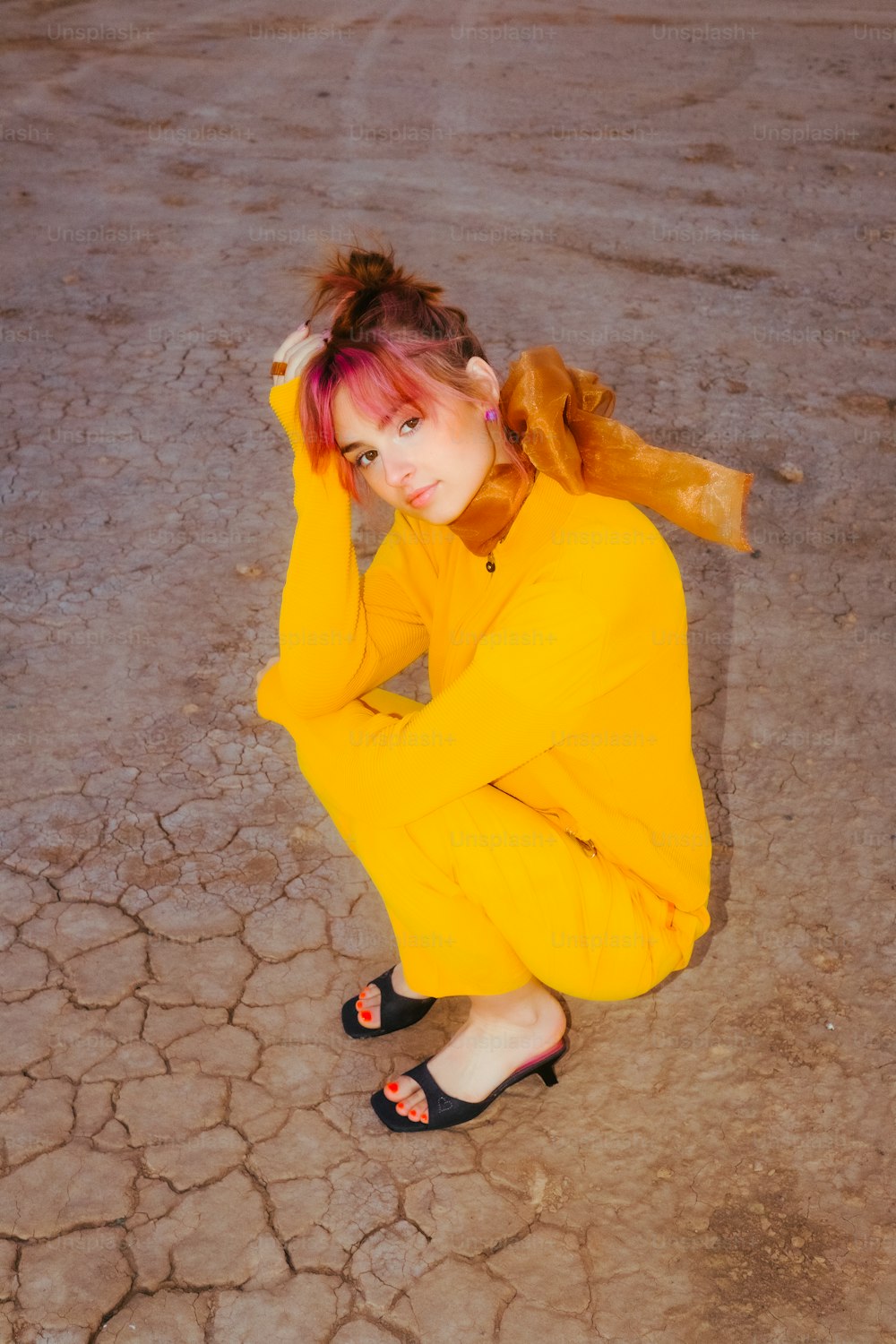 a woman in a yellow outfit sitting on the ground
