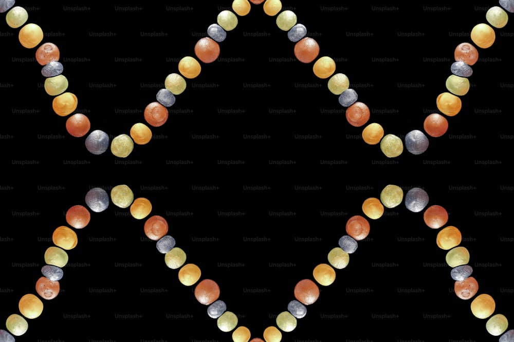a string of beads with different colors on a black background