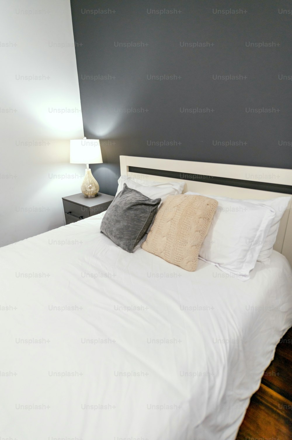 a bed with a white comforter and two lamps