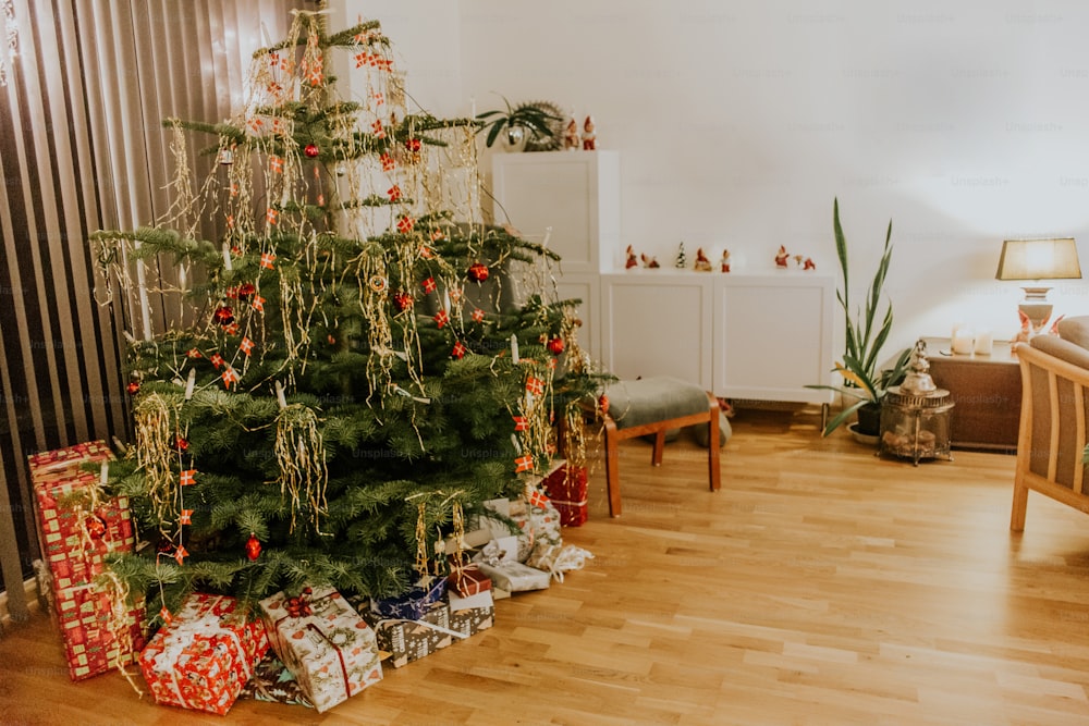 a christmas tree with presents under it in a living room