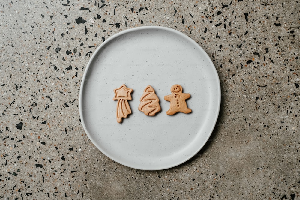 a white plate topped with cookies shaped like people