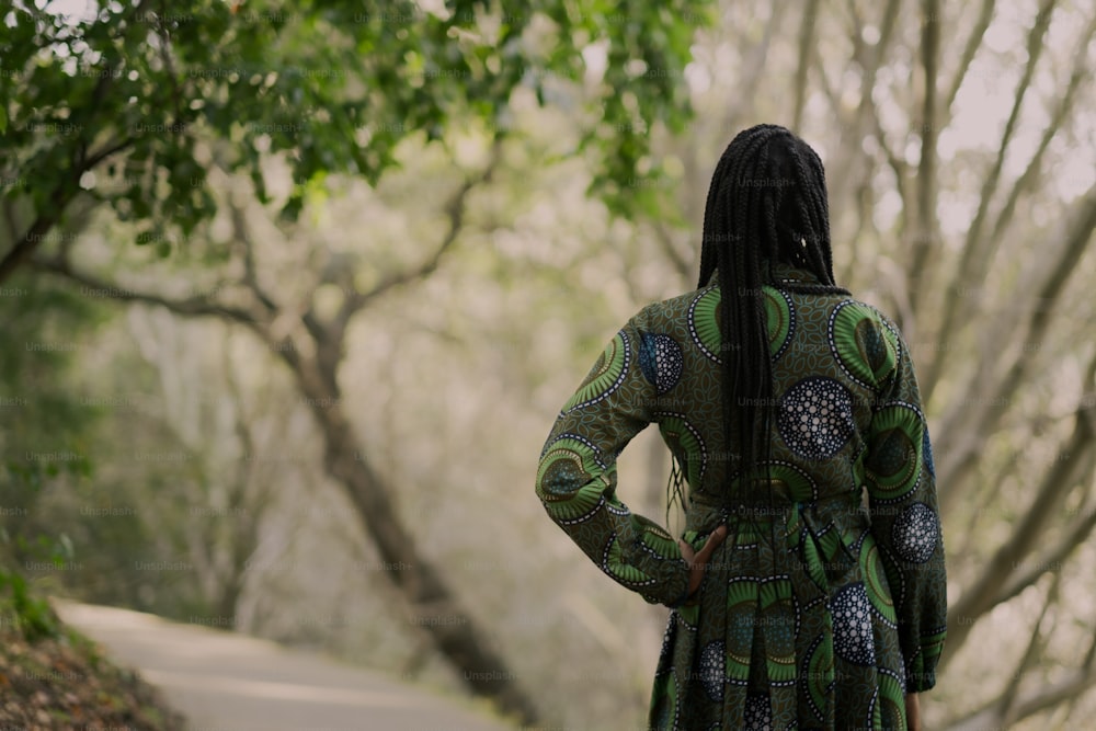 a woman in a green dress standing on a path