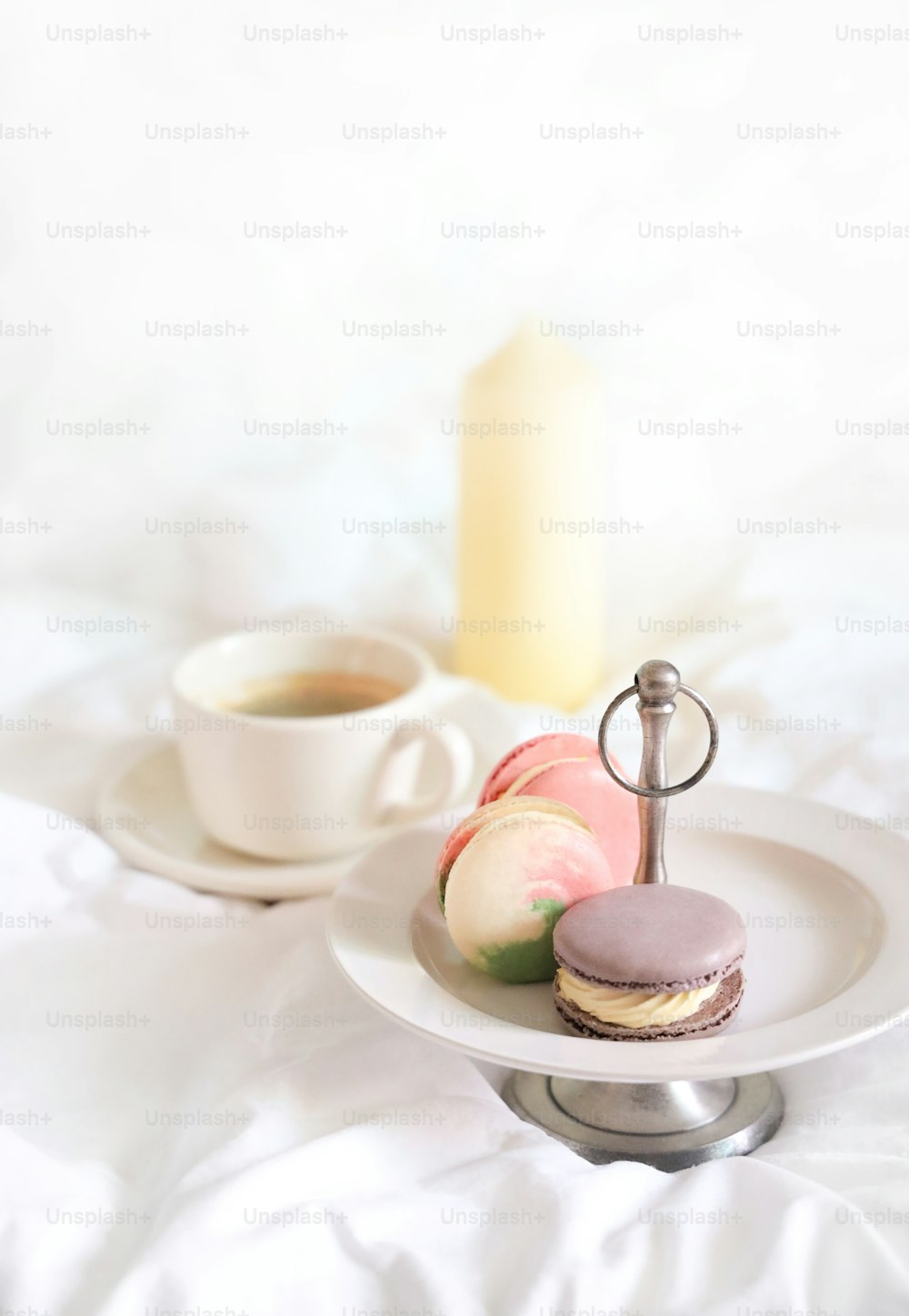 a white plate topped with macaroons next to a cup of coffee