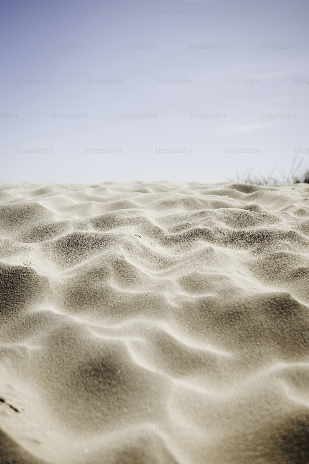 Ein Sandstrand mit blauem Himmel im Hintergrund
