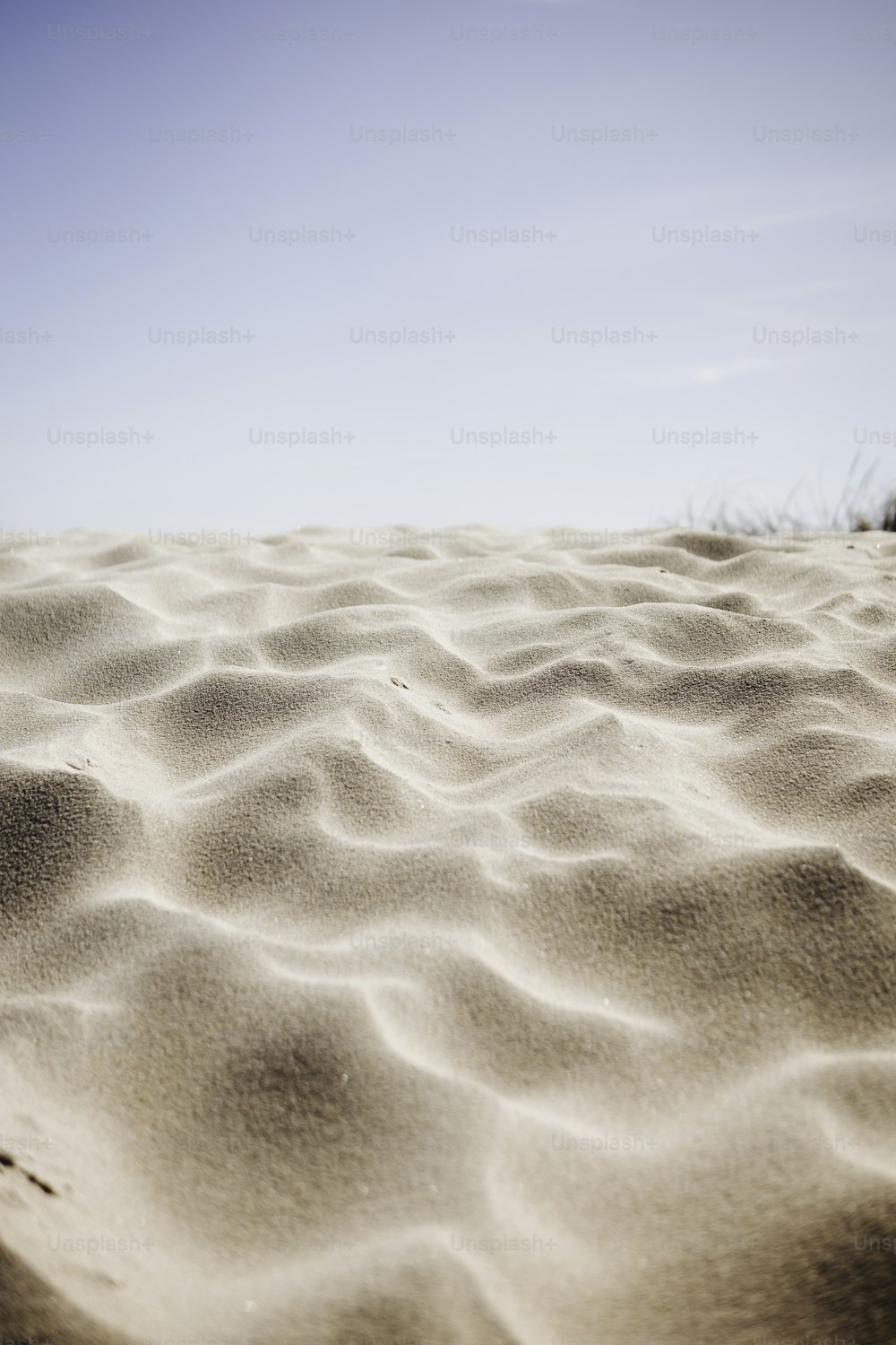 a sandy beach with a blue sky in the background