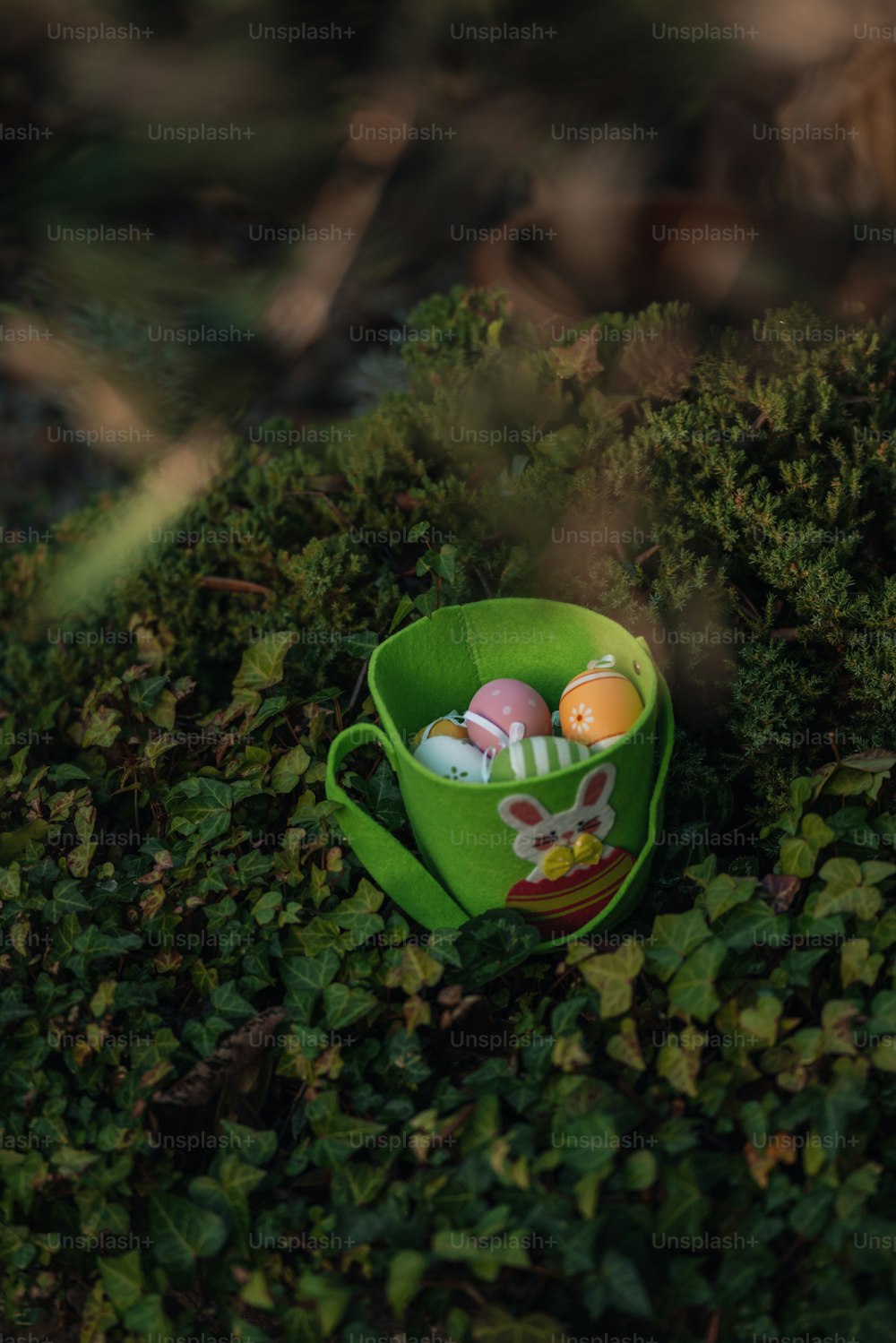 a green cup filled with eggs sitting on top of a lush green field