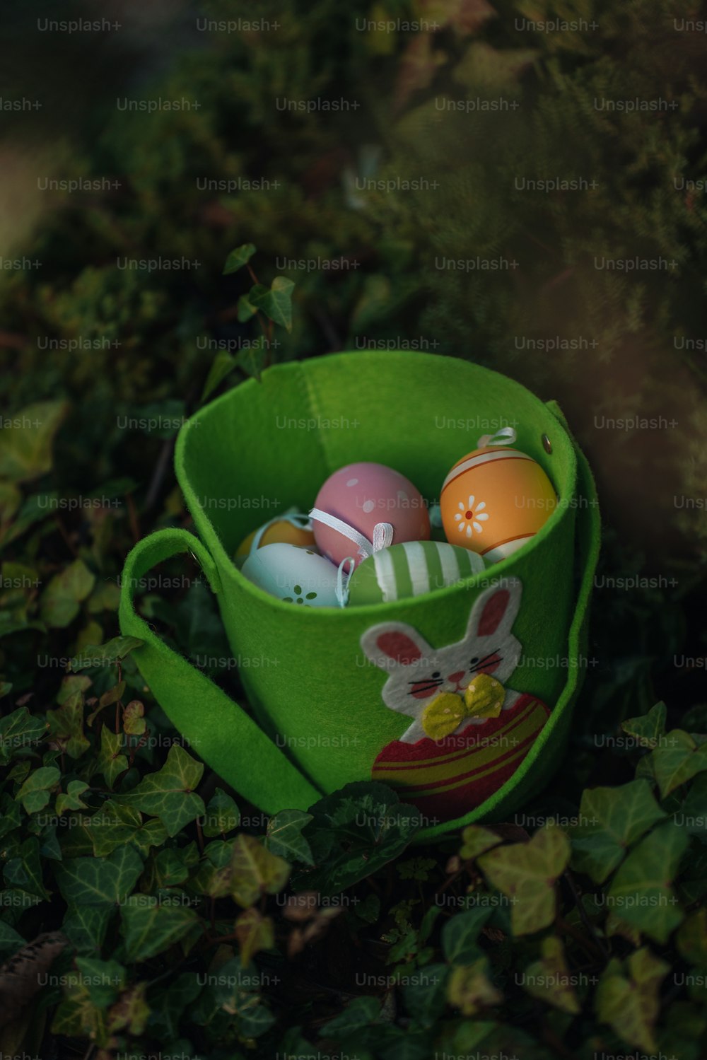 a green cup filled with eggs sitting on top of a lush green field