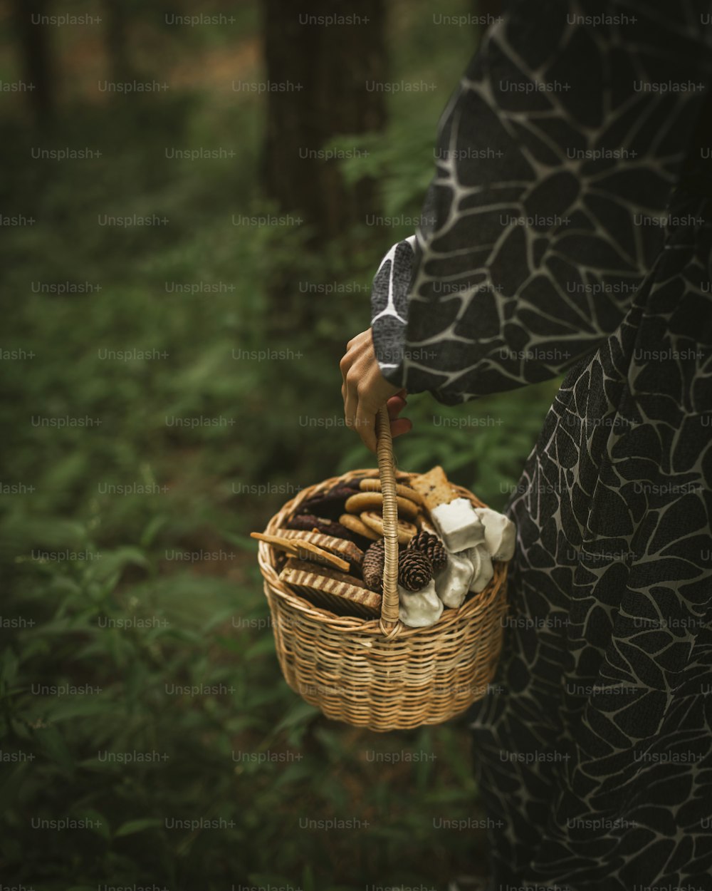 a woman holding a basket of food in a forest