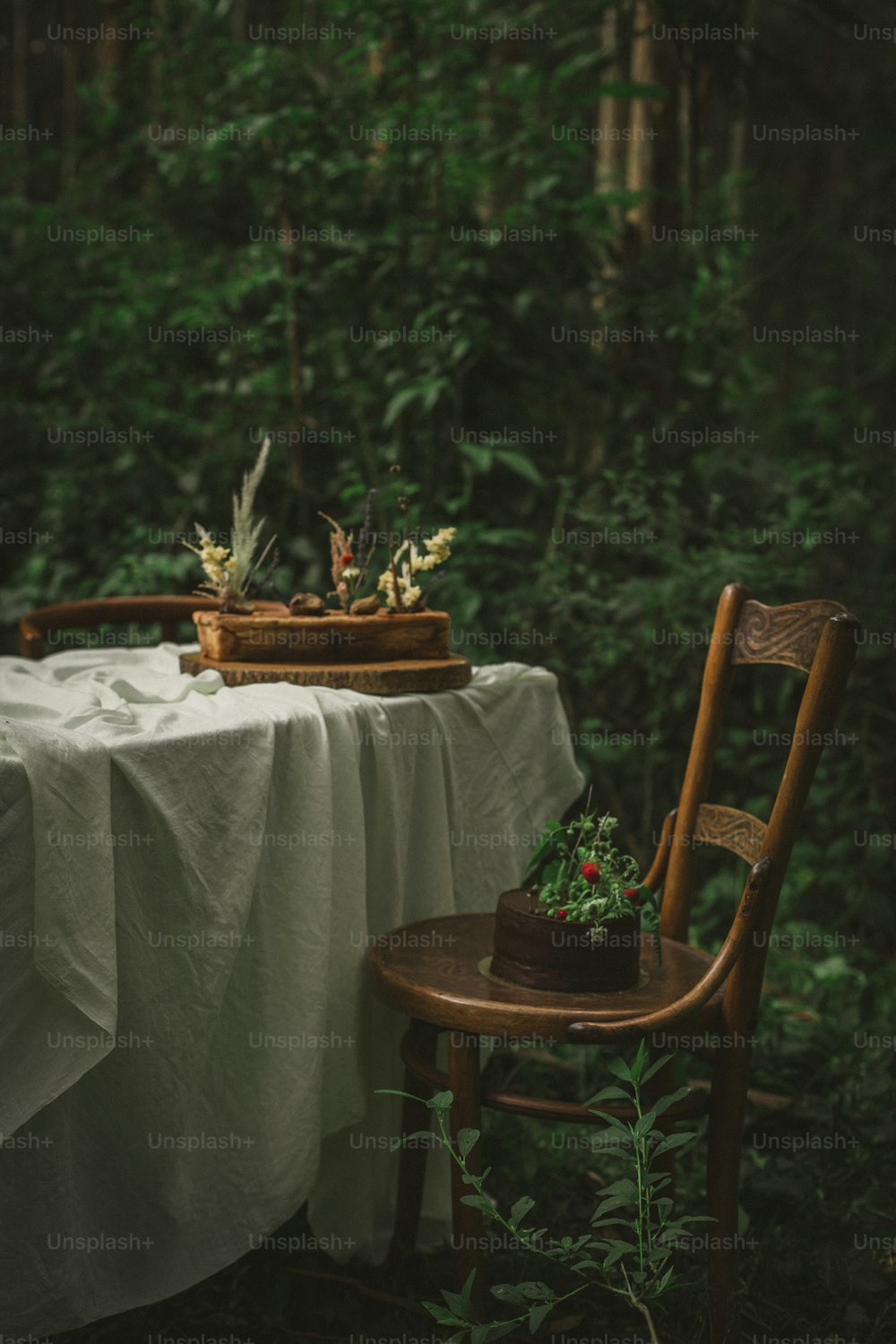 uma mesa com uma toalha de mesa branca e uma cadeira de madeira
