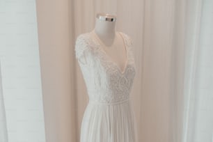 a dress on a mannequin in front of a curtain