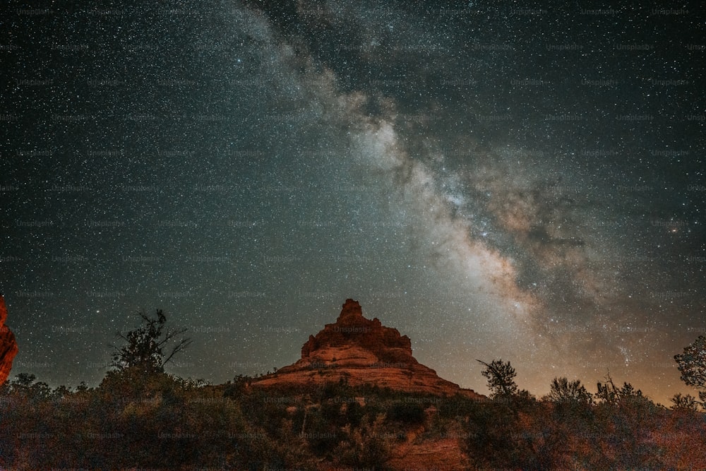 the night sky is filled with stars above a mountain