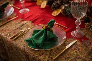 a red table cloth with a green napkin on it