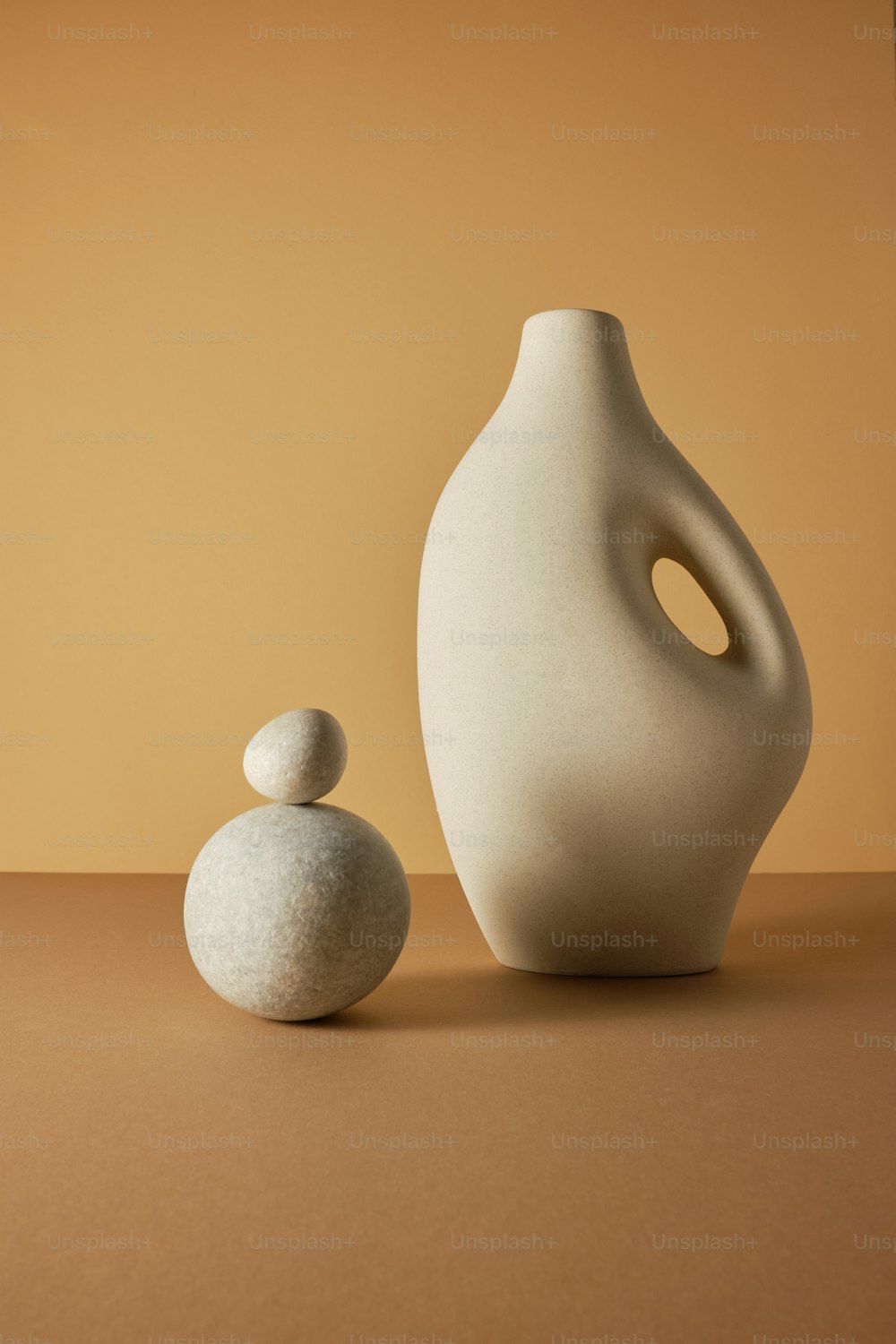 eine weiße Vase, die neben einem weißen Felsen sitzt