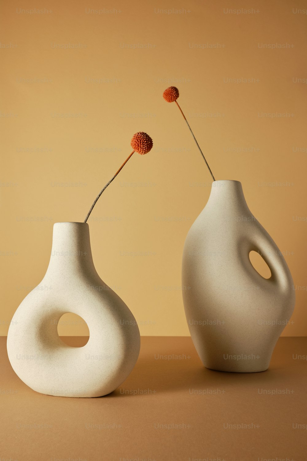 um par de vasos brancos sentados em cima de uma mesa