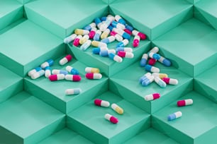 Un montón de píldoras sentadas encima de una caja verde