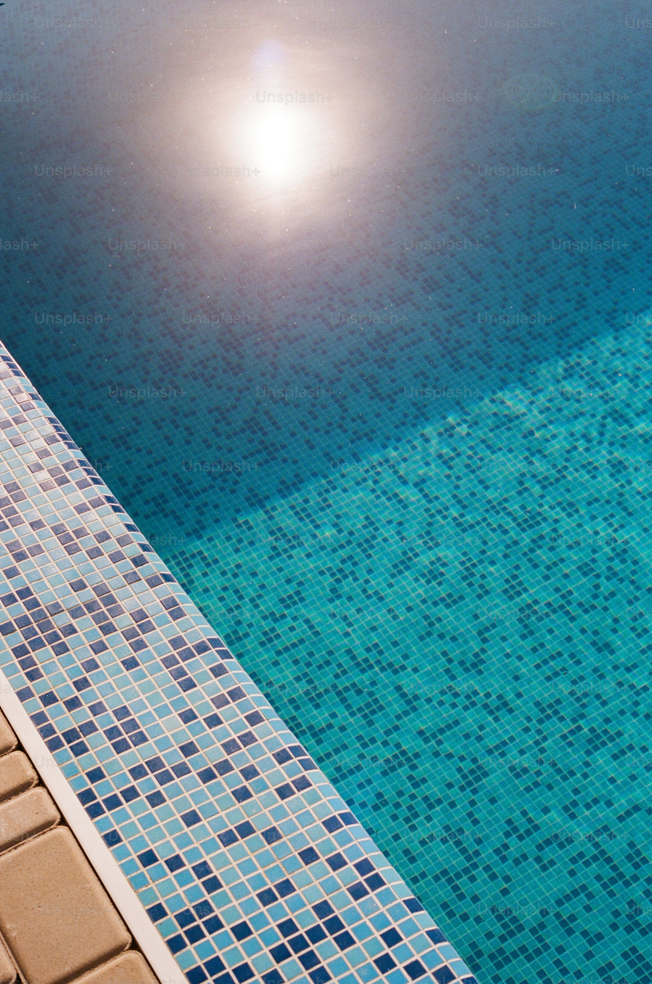the sun is shining over a swimming pool