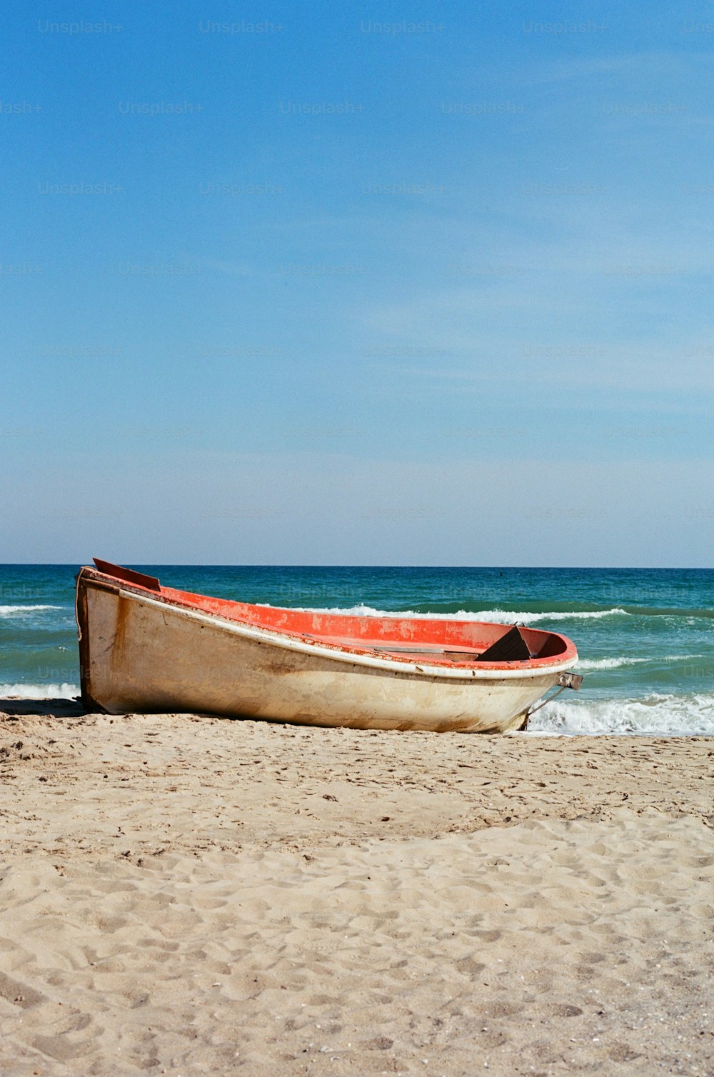 um barco sentado no topo de uma praia de areia
