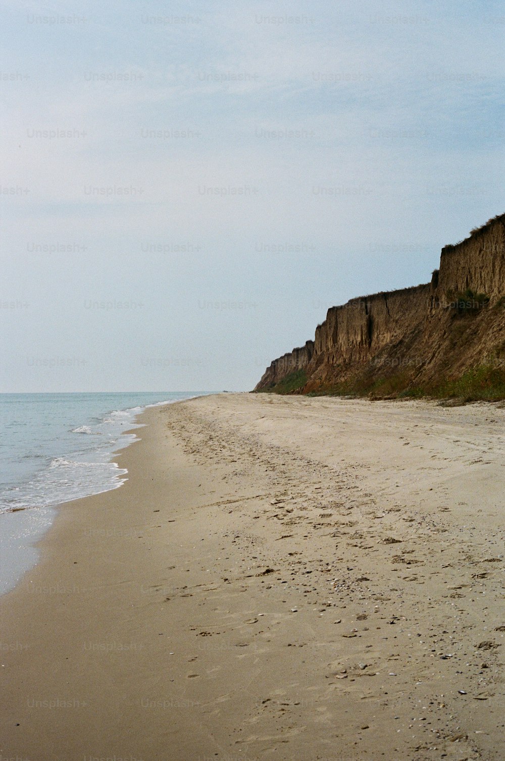 Una playa de arena con un acantilado al fondo