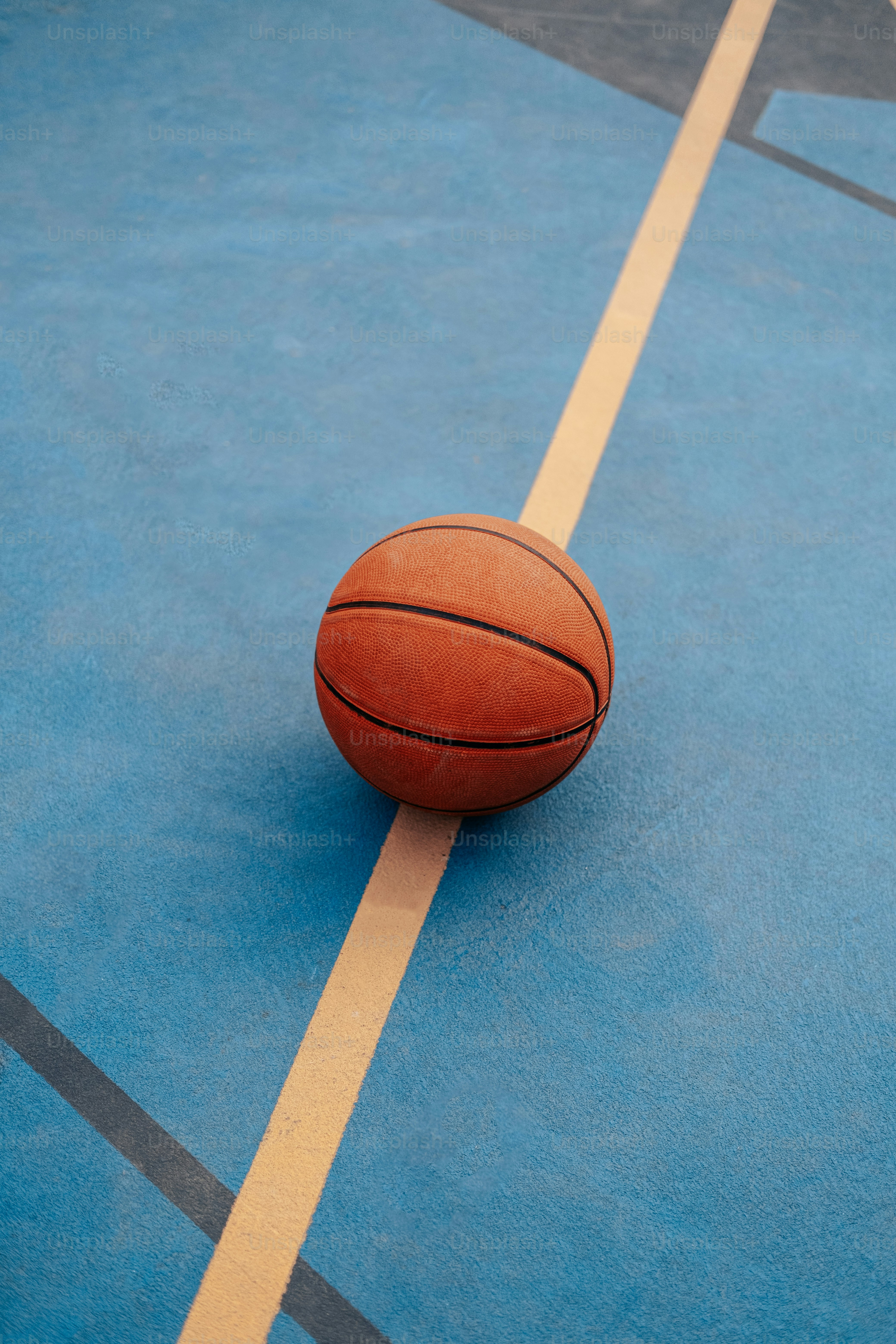 a basketball sitting on top of a blue court