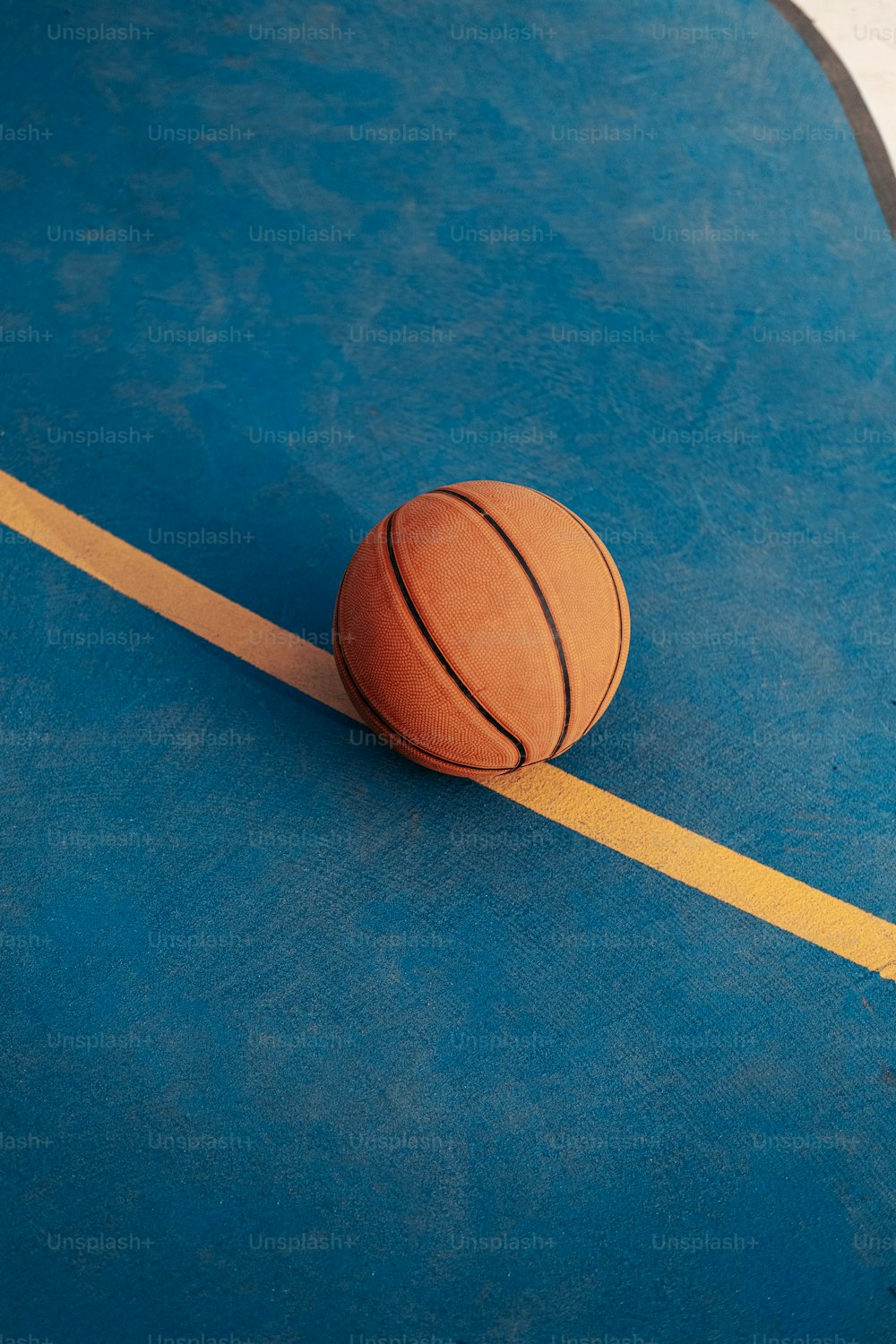 a basketball sitting on top of a blue court