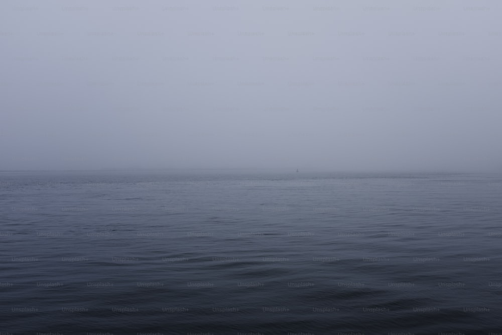 a large body of water with a boat in the distance