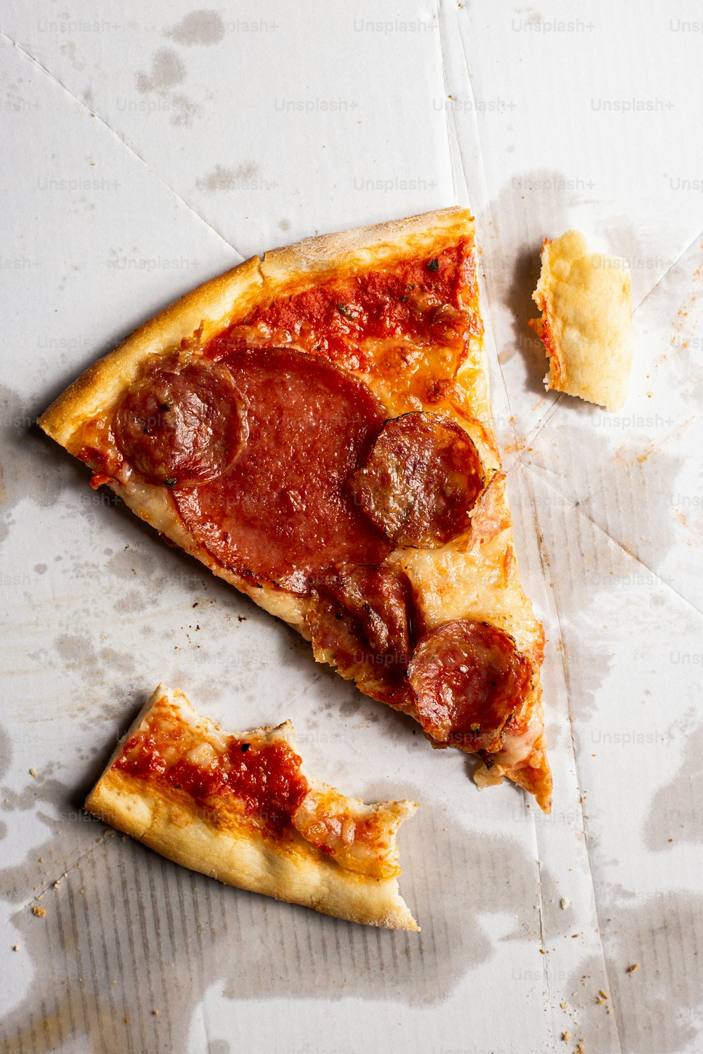 ein Stück Peperoni-Pizza, das auf einem Tisch sitzt