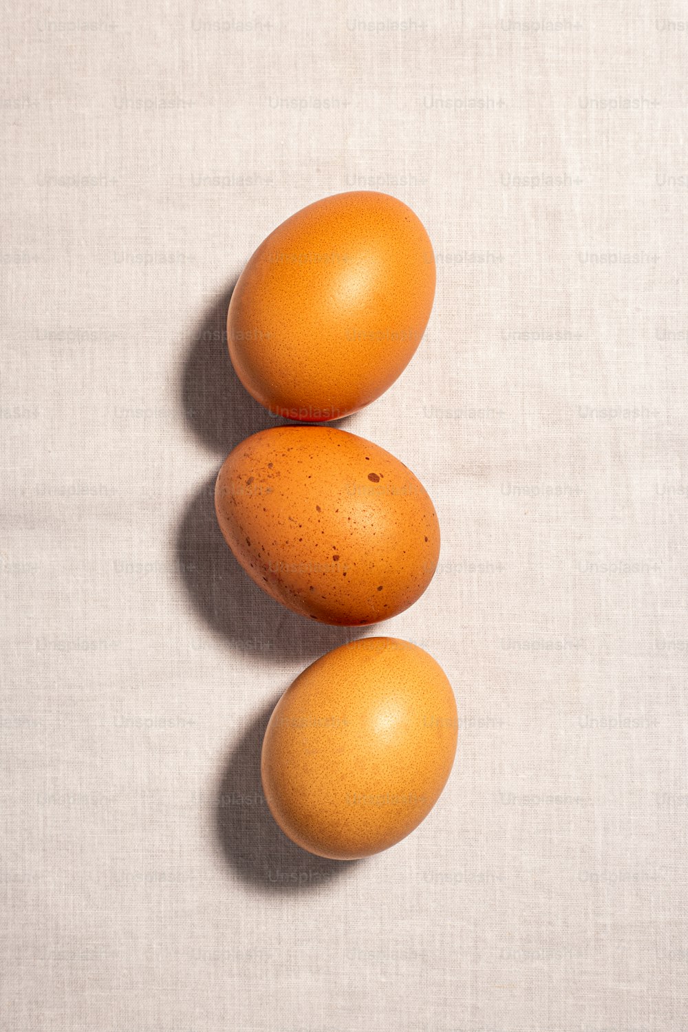 Tre uova marroni sedute una sopra l'altra