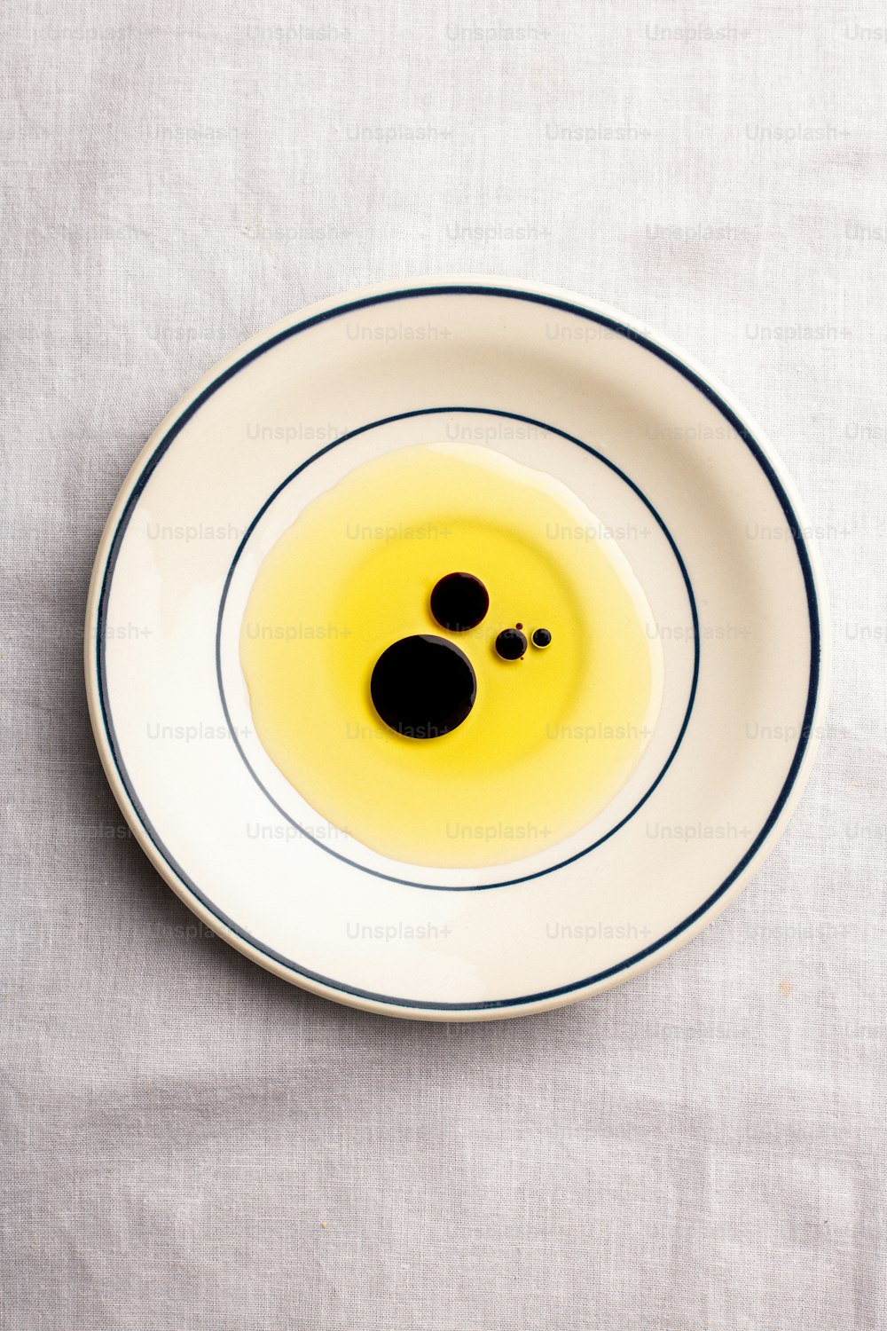 ein weißer Teller mit einer gelben Flüssigkeit darin