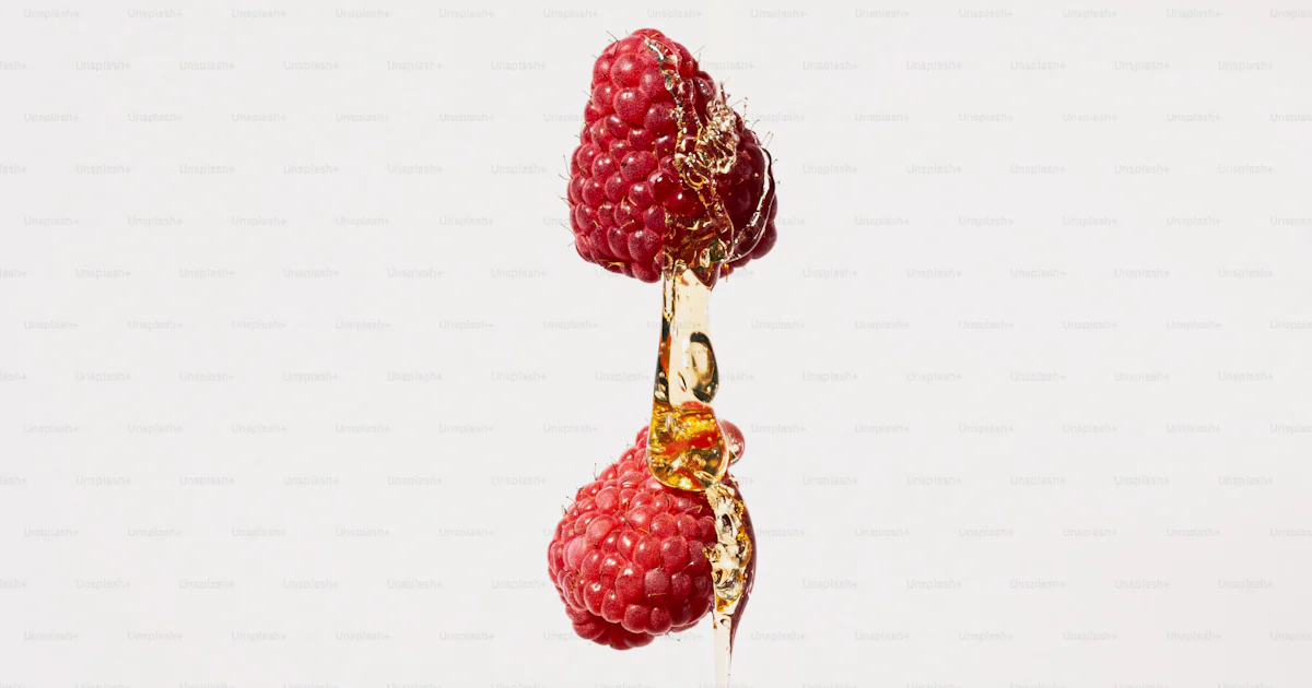 A group of raspberries hanging from a string photo – Honey Image on ...