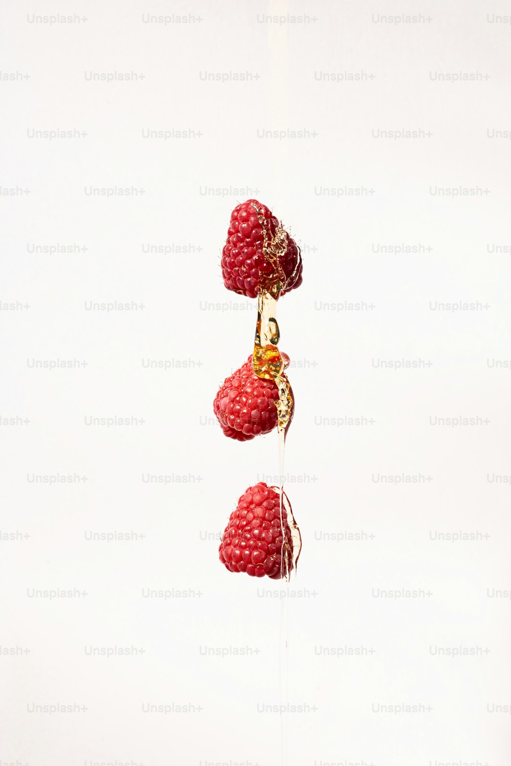 a group of raspberries hanging from a string