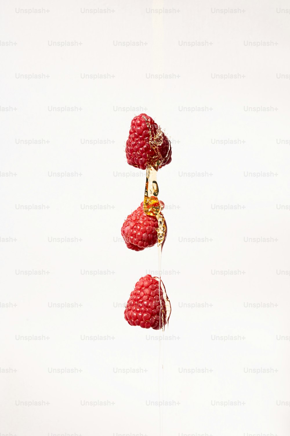 a group of raspberries hanging from a string