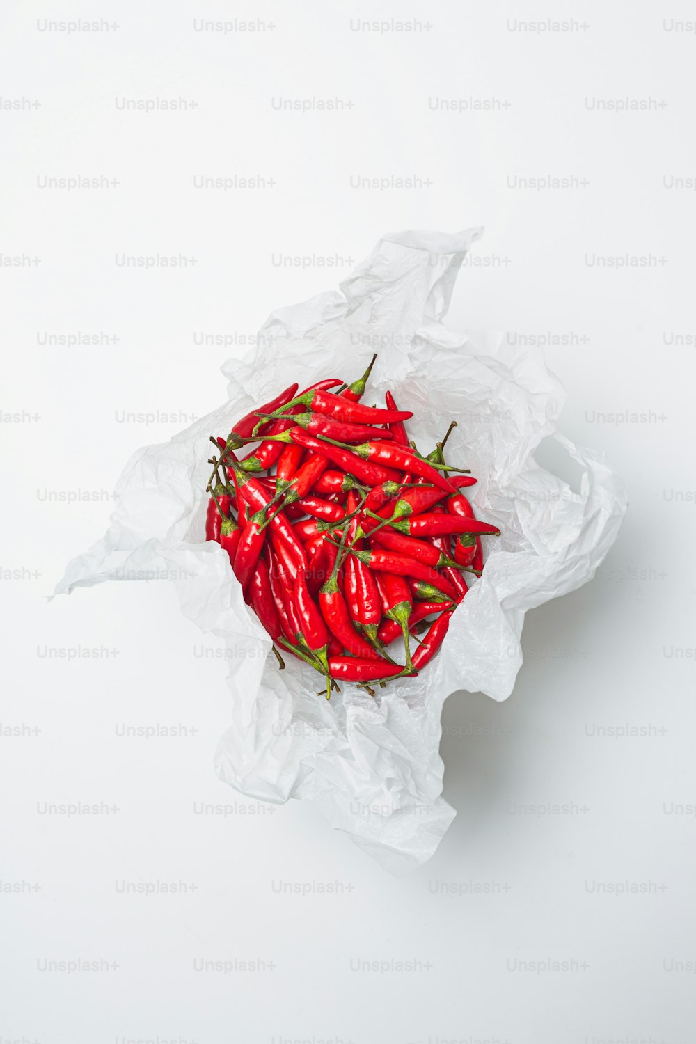 a white bag filled with red peppers on top of a table