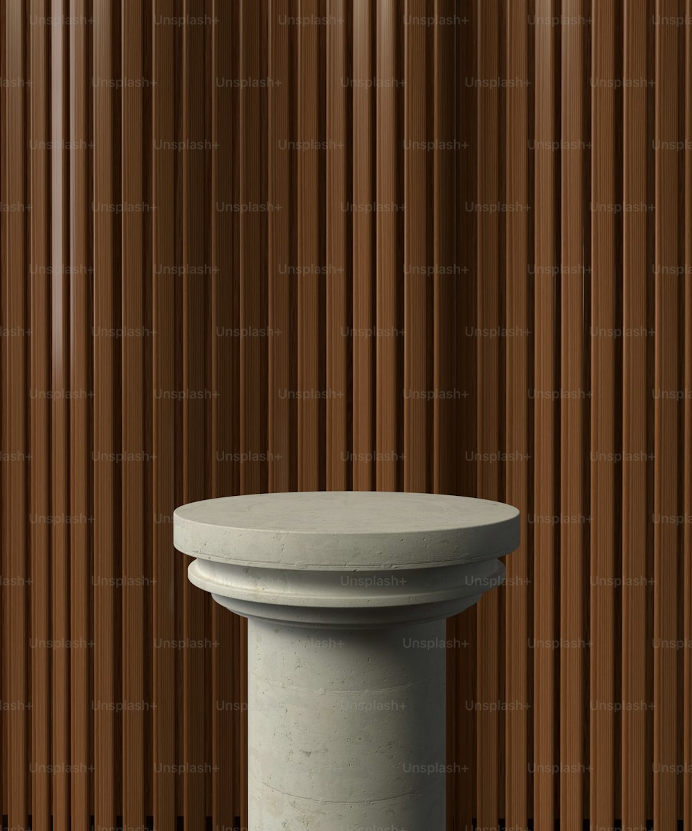 a white pedestal sitting in front of a wooden wall