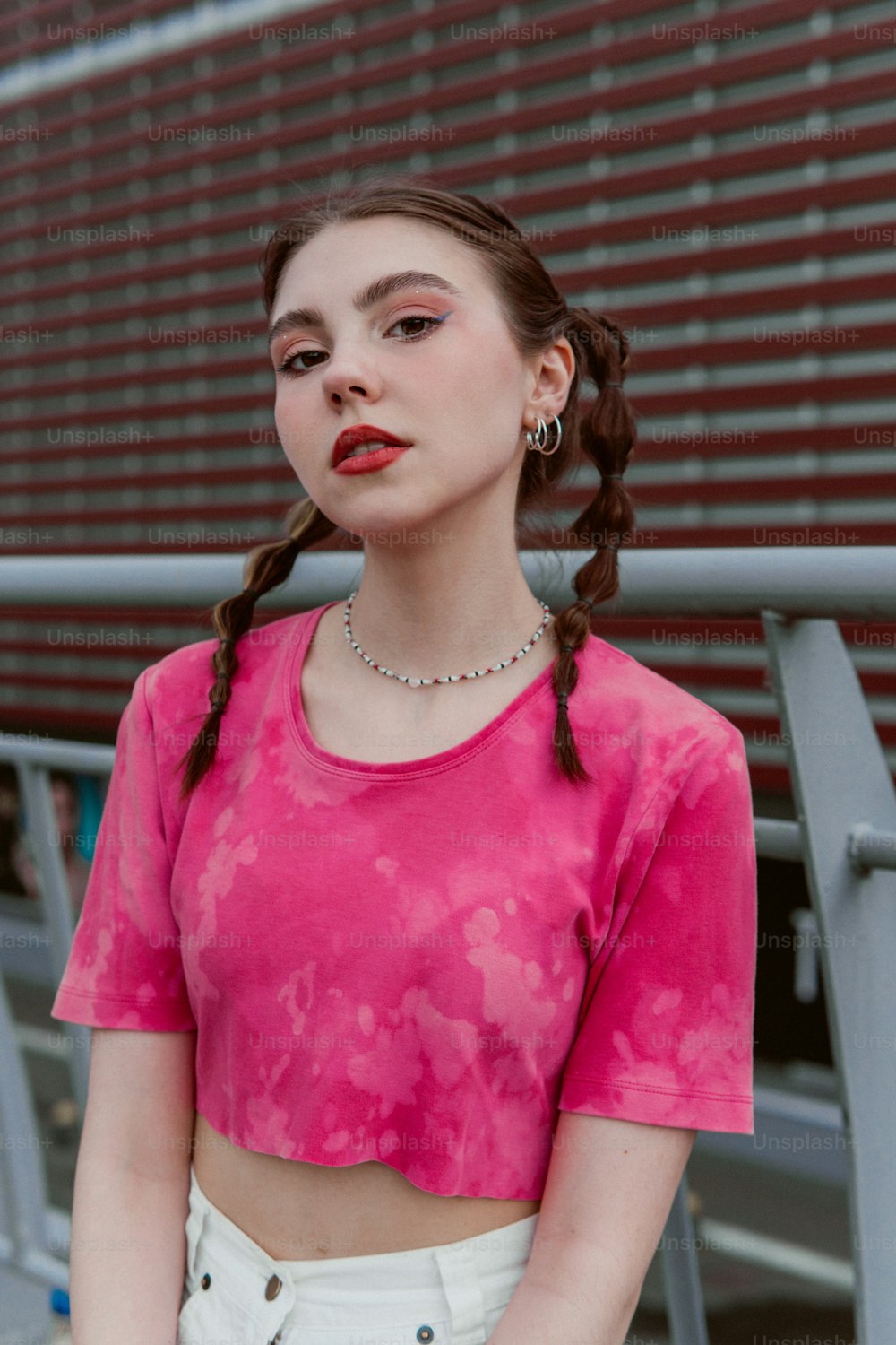 a woman wearing a pink crop top and white shorts