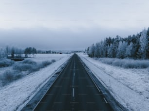 a road in the middle of a snowy field