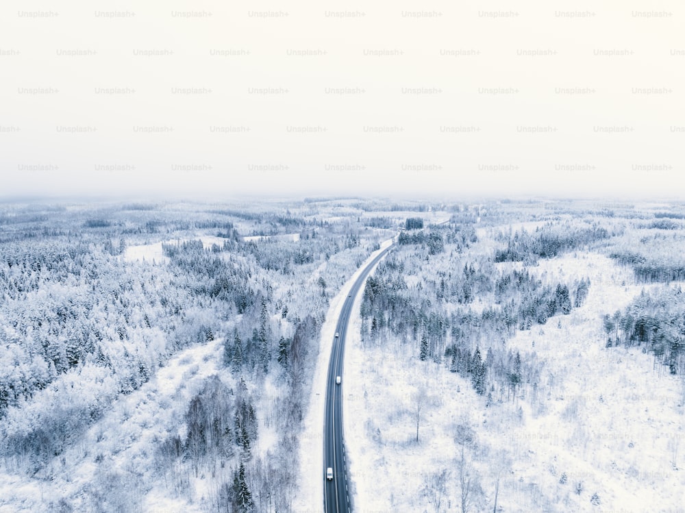 Vue aérienne d’une route au milieu d’une forêt enneigée