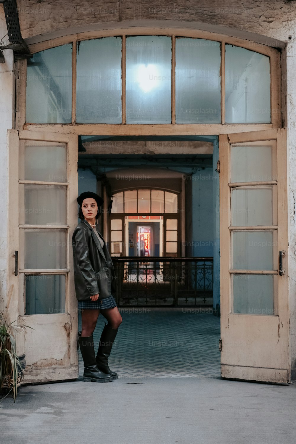 une femme debout dans l’embrasure d’une porte d’un immeuble