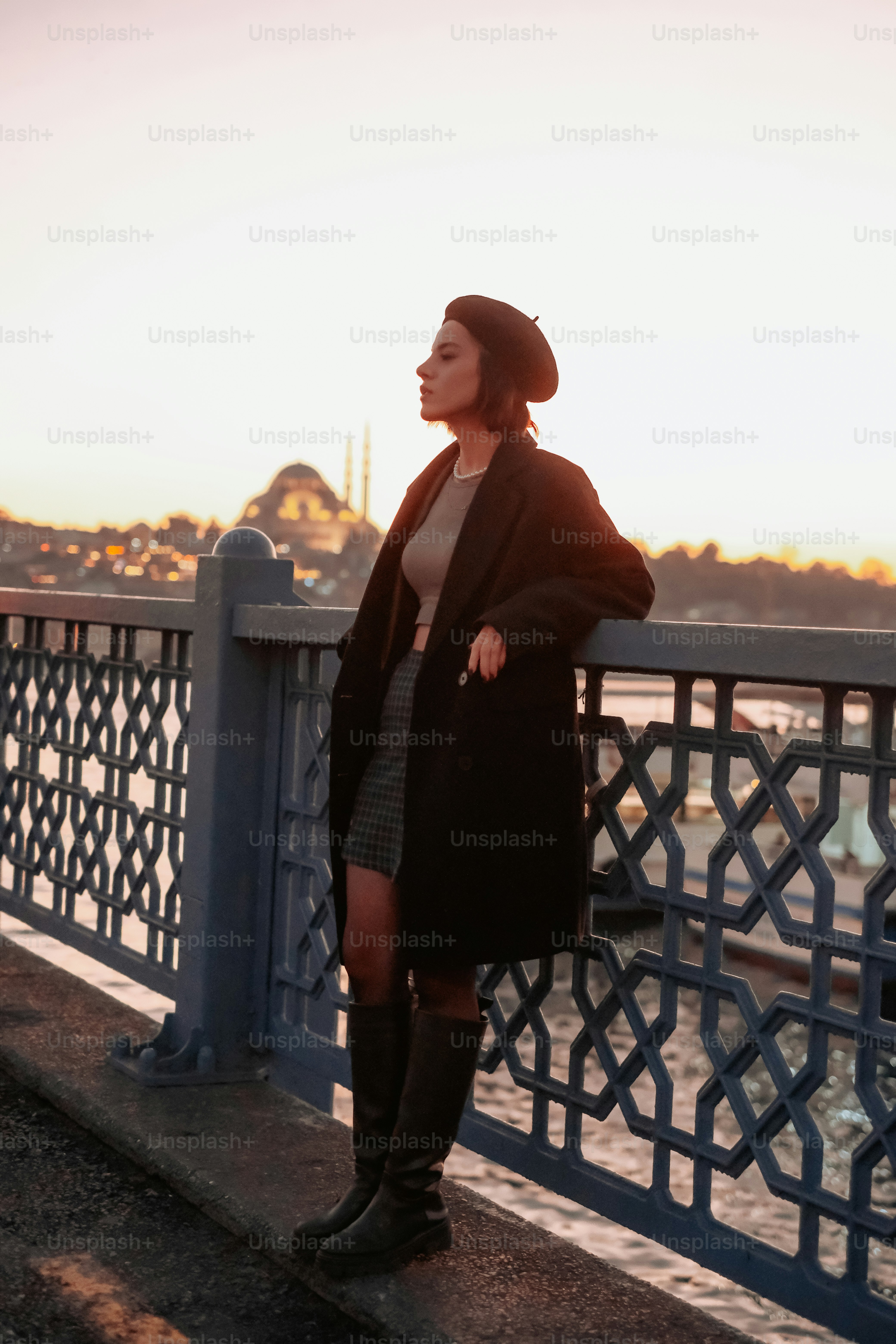 a woman standing on a bridge next to a body of water