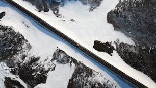 an aerial view of a train traveling through a snowy landscape